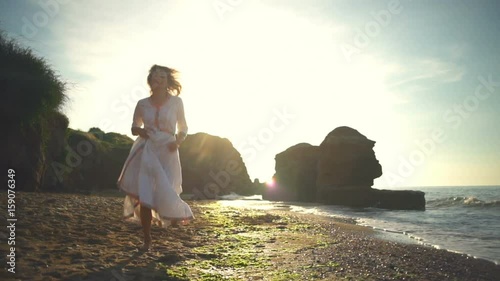 Young Happy health beautiful summer woman run sand beach silhouette slow motion photo