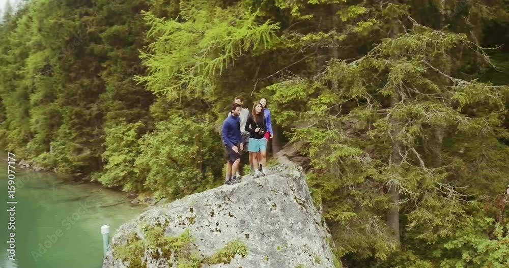 Aerial drone flight over group of friends people looking at lake.Summer adventure journey in mountain nature outdoors. Travel exploring Alps, Dolomites, Braies, Italy. 4k video orbit Aerial drone flight over group of friends people looking at lake.Summer adventure journey in mountain nature outdoors. Travel exploring Alps, Dolomites, Braies, Italy. 4k video orbit