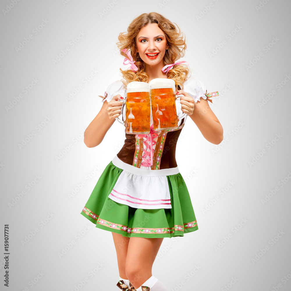Serving with smile / Beautiful Oktoberfest woman wearing a traditional Bavarian dress dirndl serving beer mugs on grey background. Serving with smile / Beautiful Oktoberfest woman wearing a traditional Bavarian dress dirndl serving beer mugs on grey background.