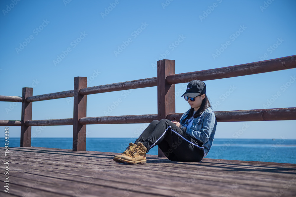 The woman sitting outside on a Board