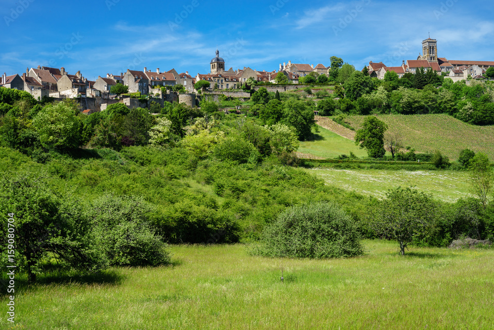 F, Burgund, Auxois, Blick auf Vezeley mit saftig grünen Weiden und strahlend blauem Himmel, 