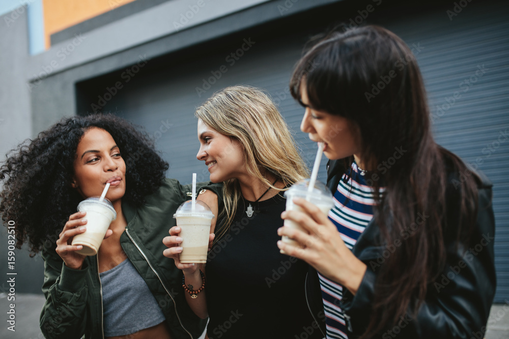 Group of female friends having ice coffee outdoors Group of female friends having ice coffee outdoors