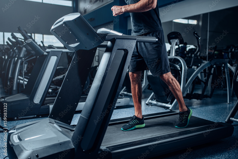 Male person workout on running exercise machine Male person workout on running exercise machine