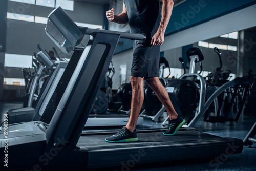 Male person workout on running exercise machine