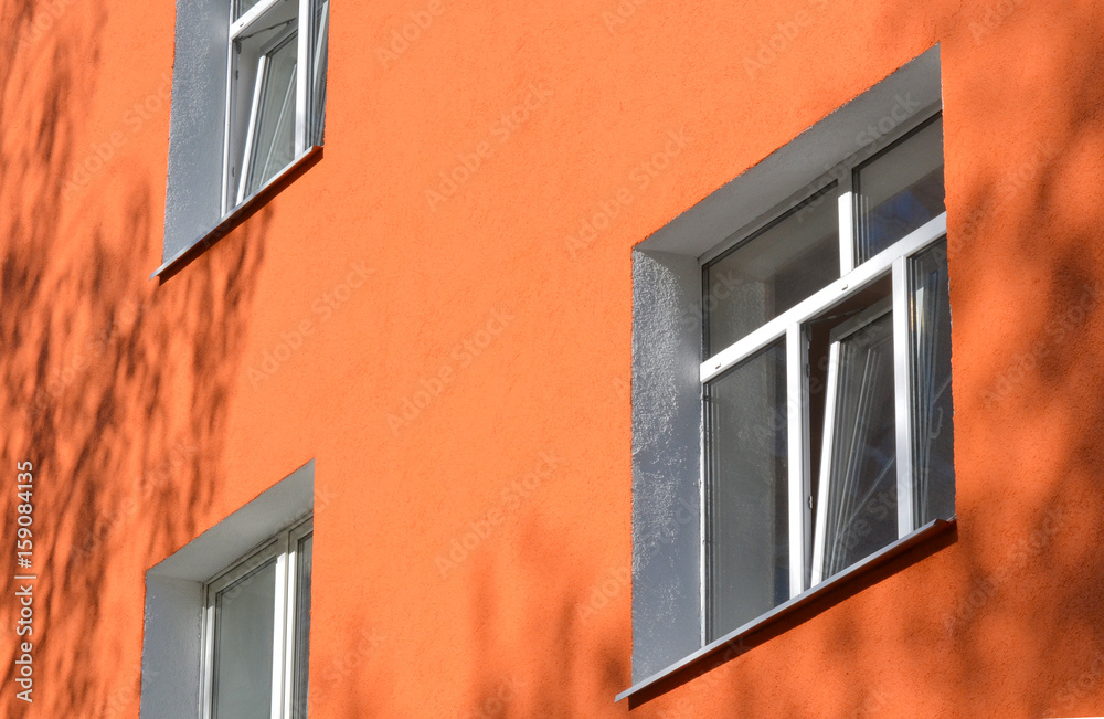 Facade building with pink walls and rows of plastic windows Facade building with pink walls and rows of plastic windows