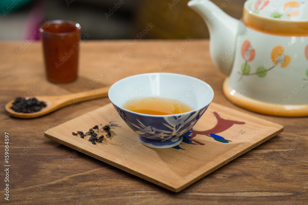 Tea cup and teapot on wooden table , close-up. Tea cup and teapot on wooden table , close-up.