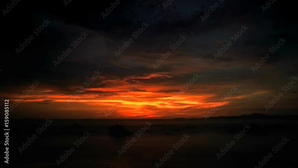 Dramatic sunrise over the ocean with clouds, highlighted from the down by the rising  sun. Timelapse FullHD 1080p.