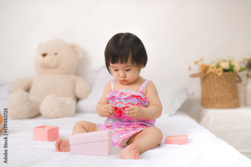 Little cute asian baby girl sitting on bed playing Little cute asian baby girl sitting on bed playing