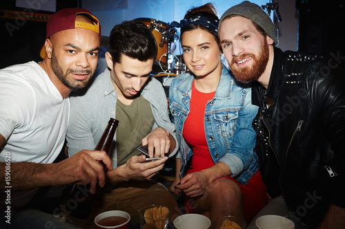 Group of young people  men and woman   looking at camera and posing in underground night club  having fun