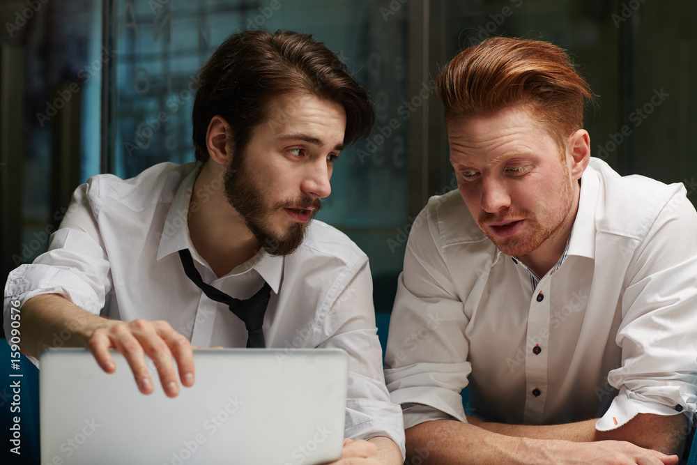 Two young businessmen discussing their plans for next day Two young businessmen discussing their plans for next day