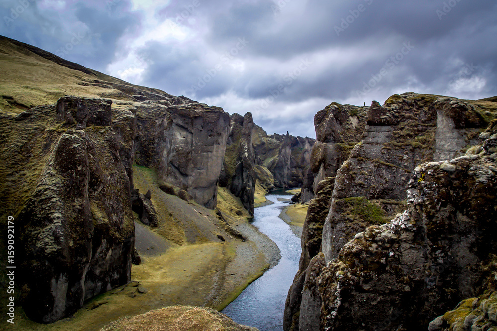 A man stands on a cliff in the Fjaðrárgljúfur canyon (Iceland) A man stands on a cliff in the Fjaðrárgljúfur canyon (Iceland)