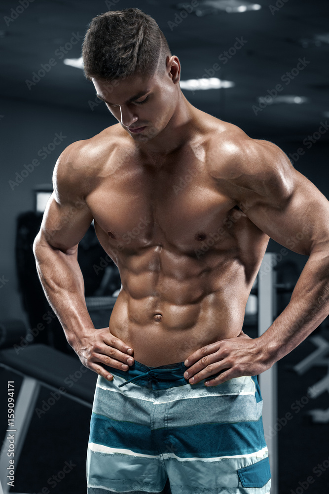 Obraz premium Muscular man in gym, abs, working out. Strong male naked torso, shaped abdominal