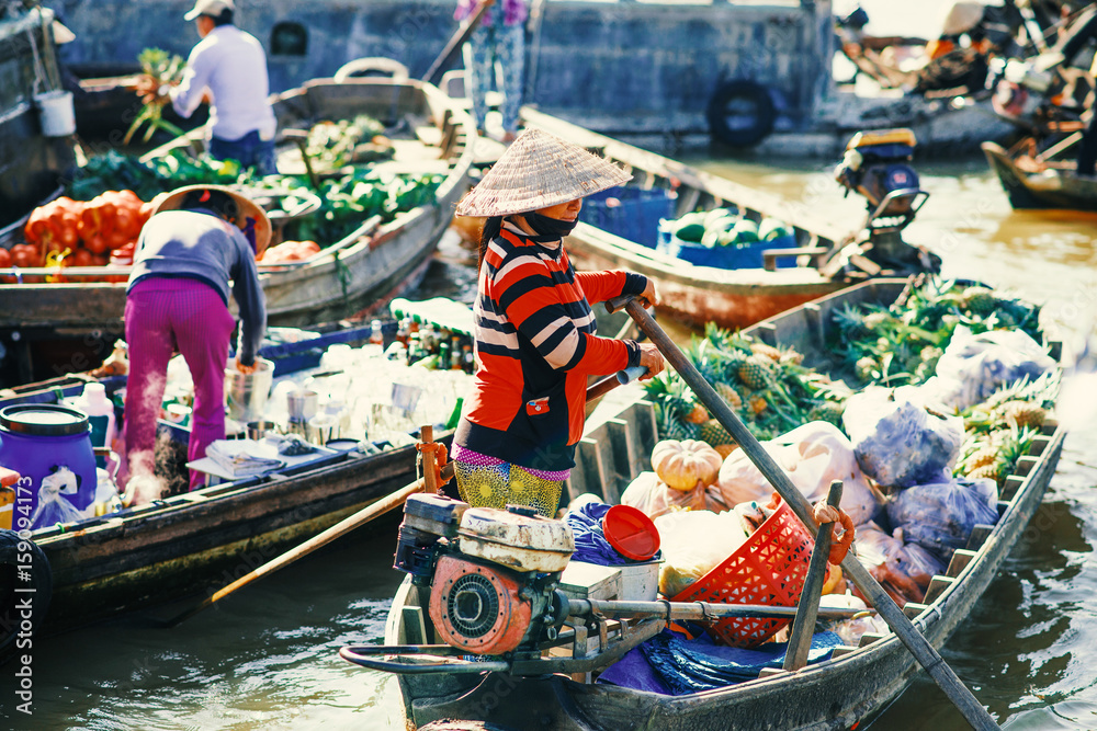 Obraz premium Unidentified people on floating market in Mekong river delta. Cai Rang and Cai Be markets are very popular among the local citizens and tourists.
