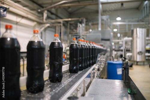 Bottling factory - Coke bottling line for processing and bottling juice into bottles. Selective focus.  photo
