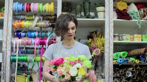 Female florist Arranging Flowers In Flower Shop