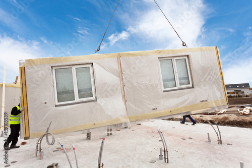 Photography Roofer builder workers with crane installing structural Insulated Panels SIP