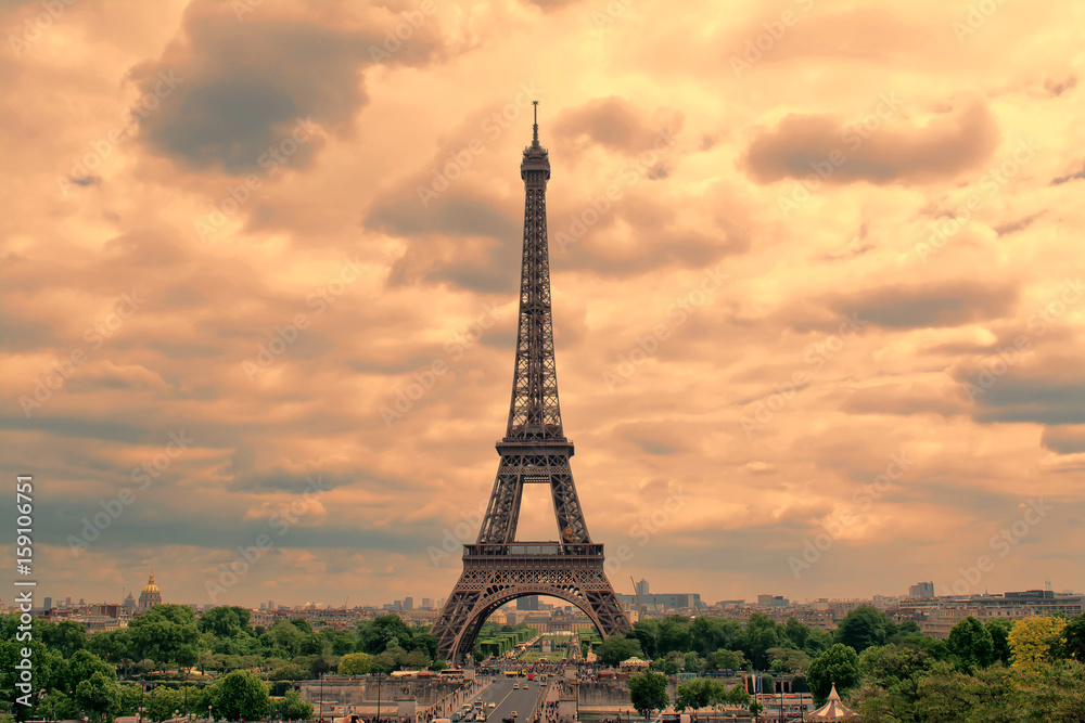 Fototapeta premium Eiffel Tower in Paris at sunset with cumulus clouds. Tour Eiffel at sunset. 