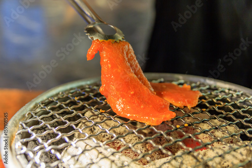 Grilling Raw Sliced Pork over Hot Charcoal Stove, Japanese Barbecue Style called Yakiniku, Selective focus