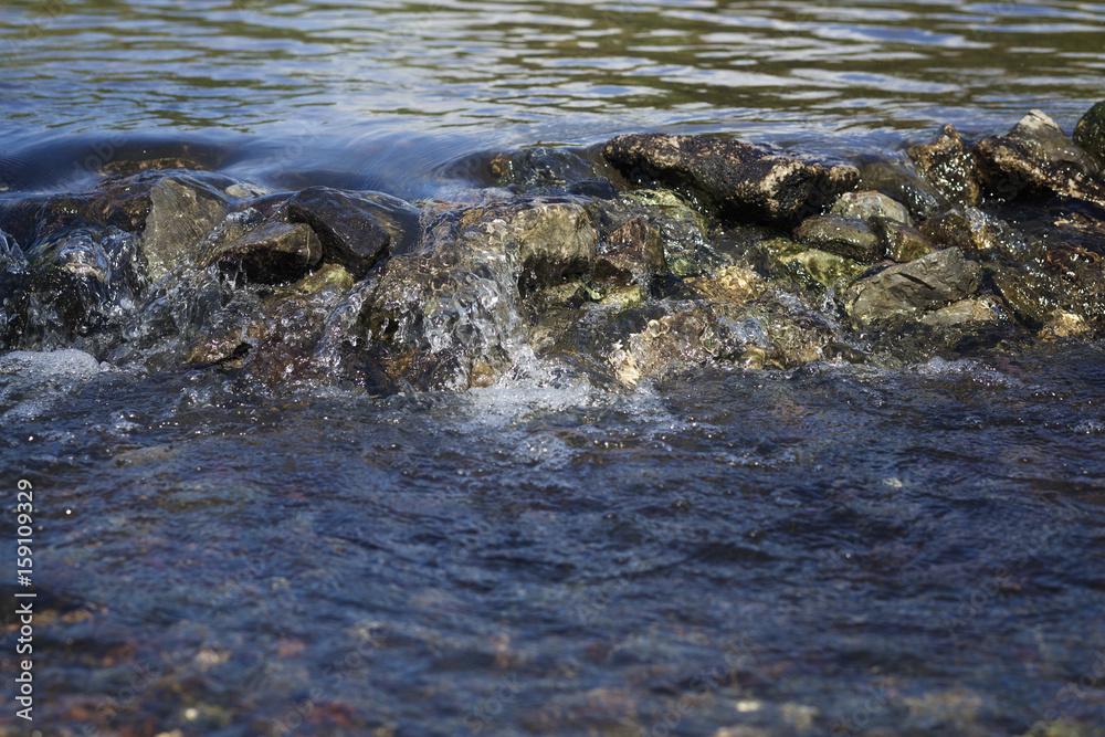 Stream flowing over stones rough rocks Stream flowing over stones rough rocks