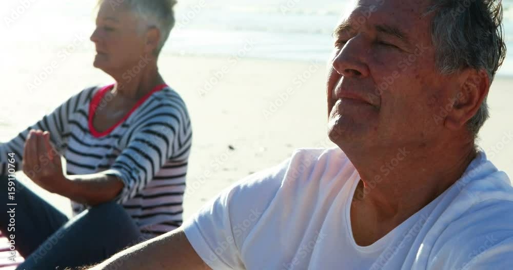 Senior couple doing yoga at beach Senior couple doing yoga at beach