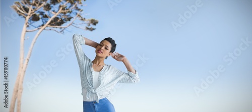Composite image of beautiful young woman standing 