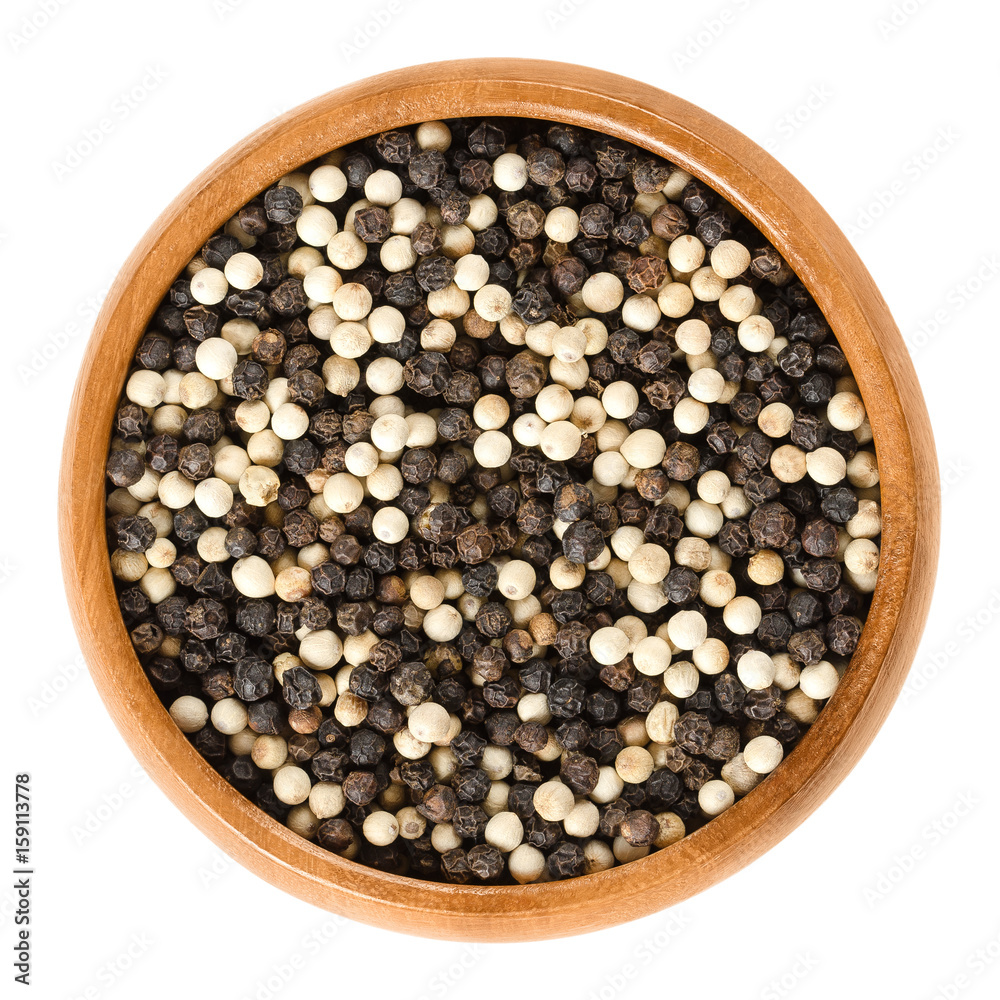 Black and white pepper in wooden bowl. Also called pepper