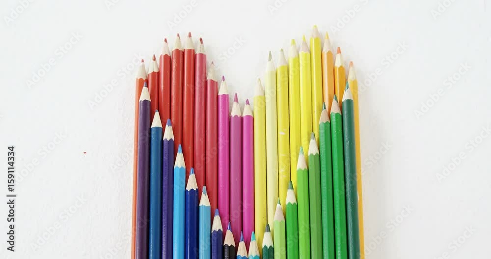 Colored pencils arranged in heart shape on white background Colored pencils arranged in heart shape on white background