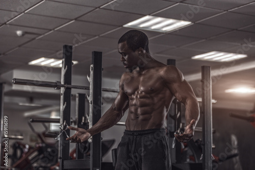 Handsome muscular man exercise in gym.