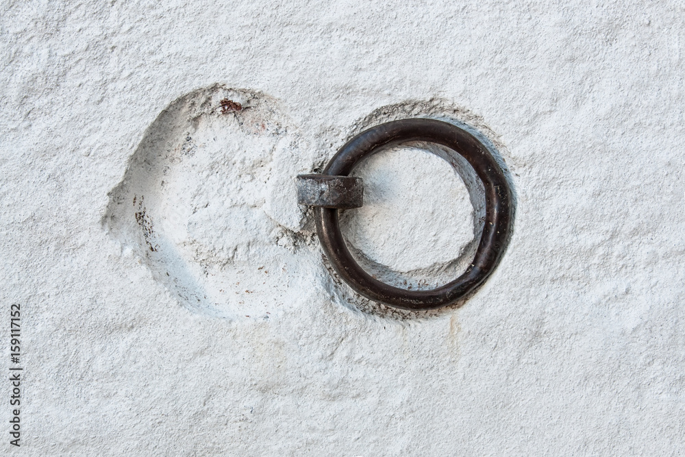 Metal ring with recesses of the old texture white concrete wall. Background. Metal ring with recesses of the old texture white concrete wall. Background.