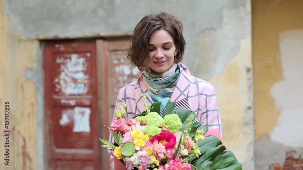 Beautiful young woman in a coat with a bouquet of flowers Beautiful young woman in a coat with a bouquet of flowers