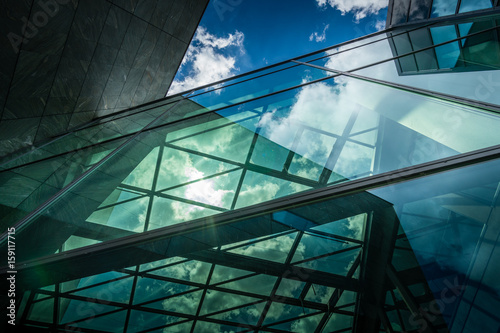 Underside panoramic and perspective view to steel blue glass high rise building with reflections