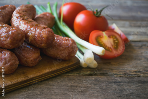  Sausages with vegetables on a wooden texture