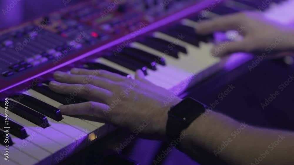 Musician playing on the keyboard synthesizer piano keys. Musician plays a musical instrument on the concert stage