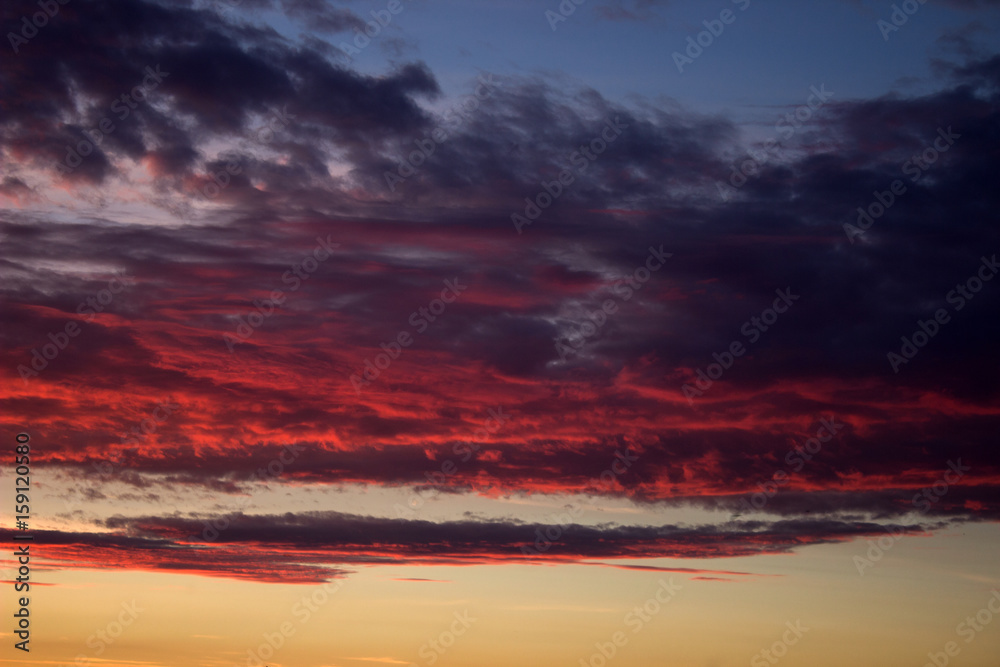 Red cloudy sky at sunset of a summer day