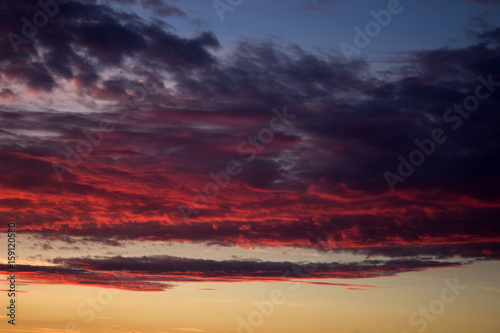 Red cloudy sky at sunset of a summer day