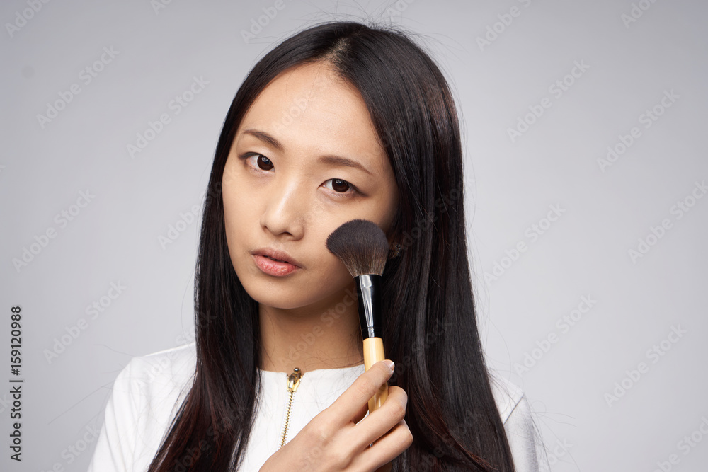 Woman asian paints makeup on face skin, woman enjoys makeup Woman asian paints makeup on face skin, woman enjoys makeup