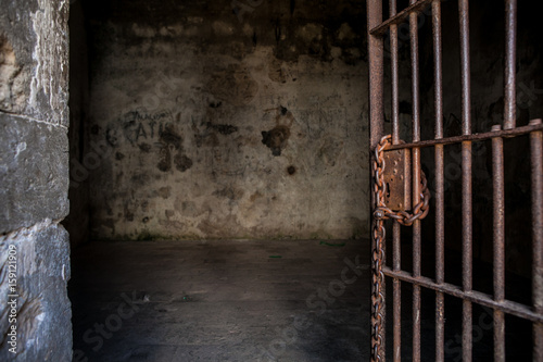 Antique abandoned prison cell with rusted chain