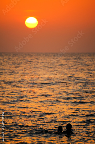 Beautiful Sunset at andaman sea with silhouette people in water