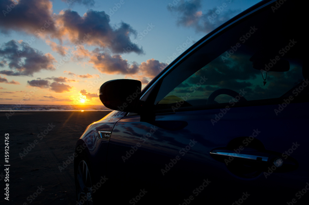 Blue sport sedan under dusk lights at sand beach
