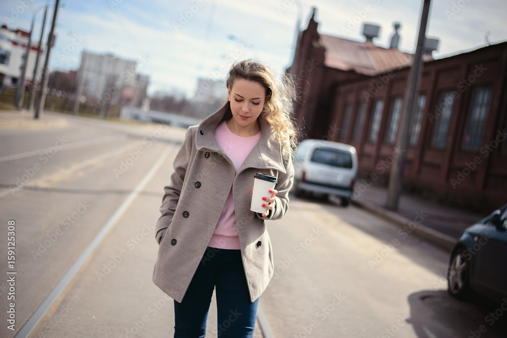 Woman walking down and drinking coffee