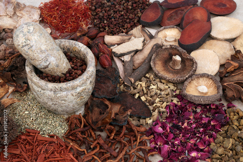 Traditional chinese herbal medicine selection with mortar and pestle forming a background. photo