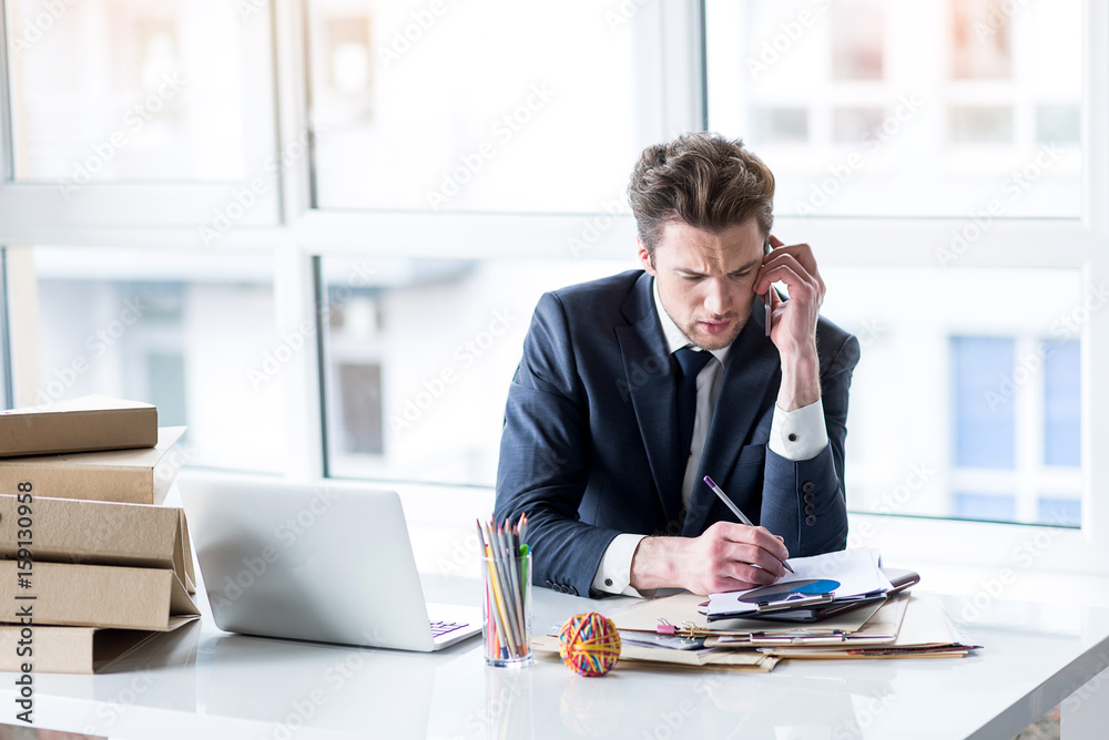 Depressed man in suit is talking on smartphone Depressed man in suit is talking on smartphone