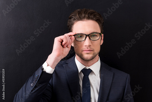 Pleasant businessman with stubble posing thoughtfully