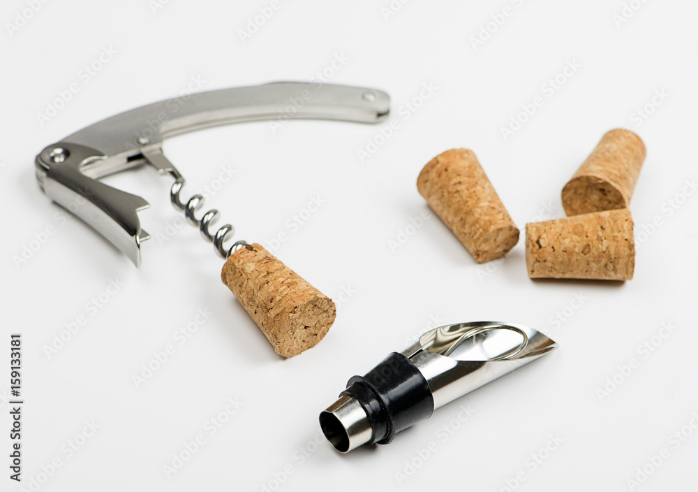 Close-up of corkscrew on white background next to several corks. Horizontal studio shot. Isolated. Close-up of corkscrew on white background next to several corks. Horizontal studio shot. Isolated.