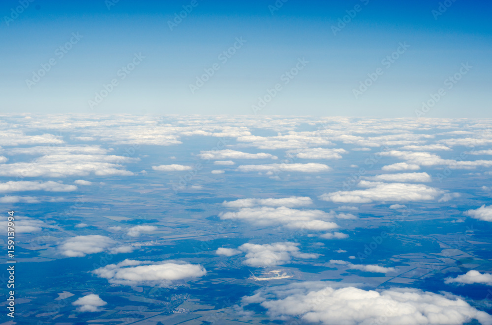 Clouds and sky as seen through window of an aircraft Clouds and sky as seen through window of an aircraft
