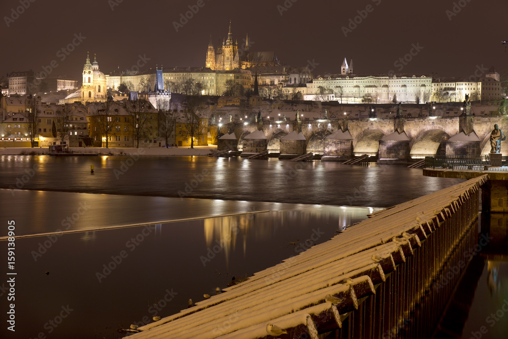 Night romantic snowy Prague gothic Castle and St. Nicholas' Cathedral with Charles Bridge, Czech republic