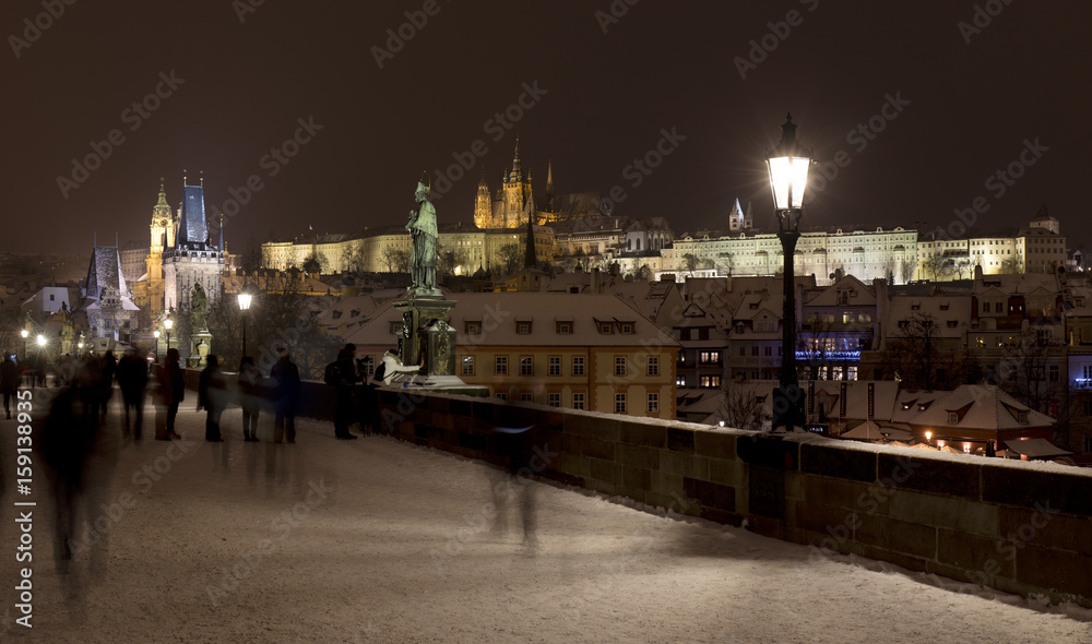 Night snowy Prague Lesser Town with gothic Castle, Bridge Tower and St. Nicholas' Cathedral from Charles Bridge with its baroque Statues, Czech republic Night snowy Prague Lesser Town with gothic Castle, Bridge Tower and St. Nicholas' Cathedral from Charles Bridge with its baroque Statues, Czech republic