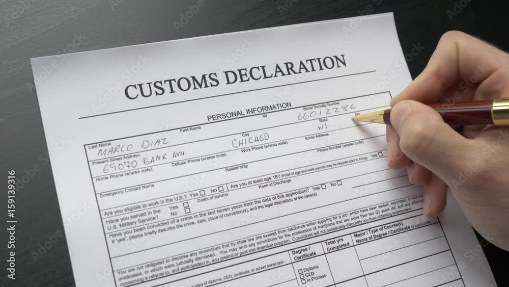 A person filling a customs declaration form. Closeup shot.