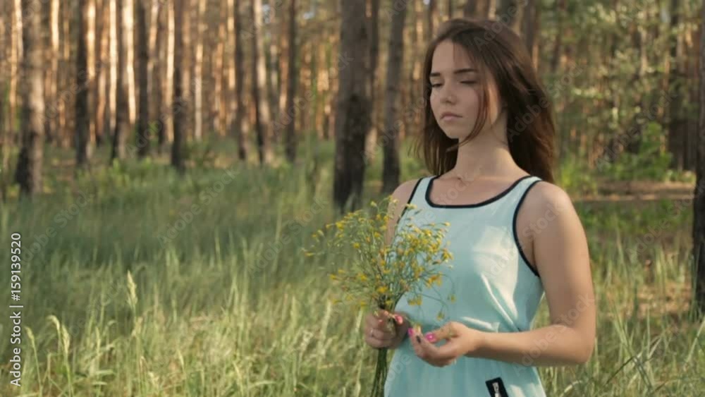 Girl with a bouquet of wild flowers in the forest Girl with a bouquet of wild flowers in the forest