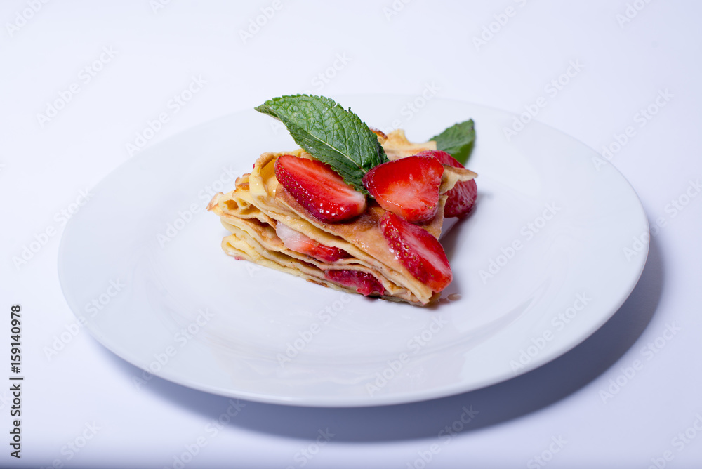 Pancakes with strawberries and mint pie with strawberries